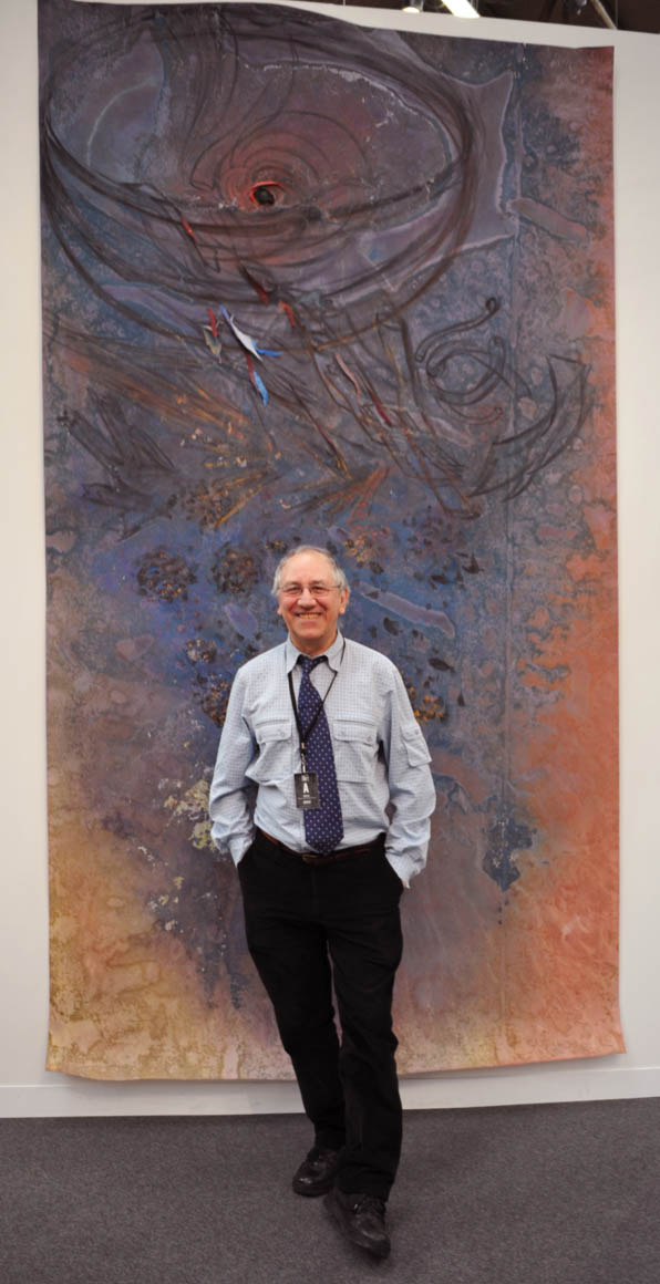 A man standing in front of an art work.